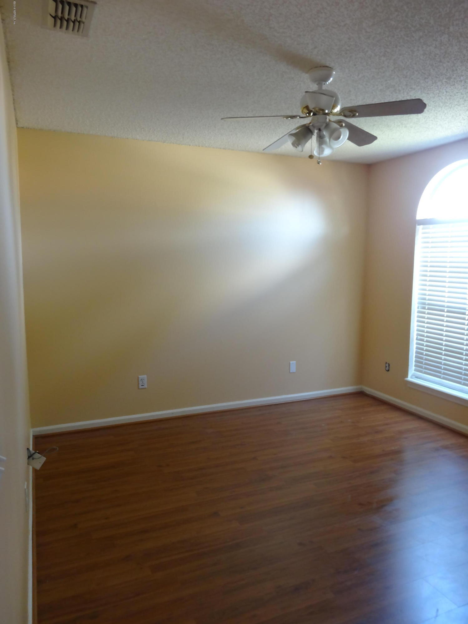 612 Morning Mist Way Orange Park, FL 32073 - Photo 12 of 12 a view of an empty room with wooden floor and a chandelier