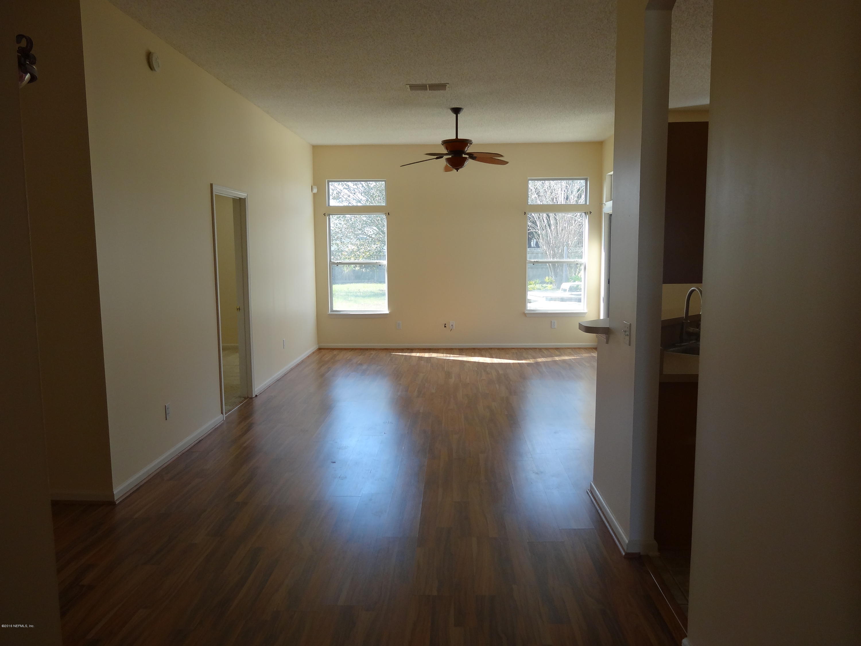 612 Morning Mist Way Orange Park, FL 32073 - Photo 2 of 12 an empty room with wooden floor windows and glass door