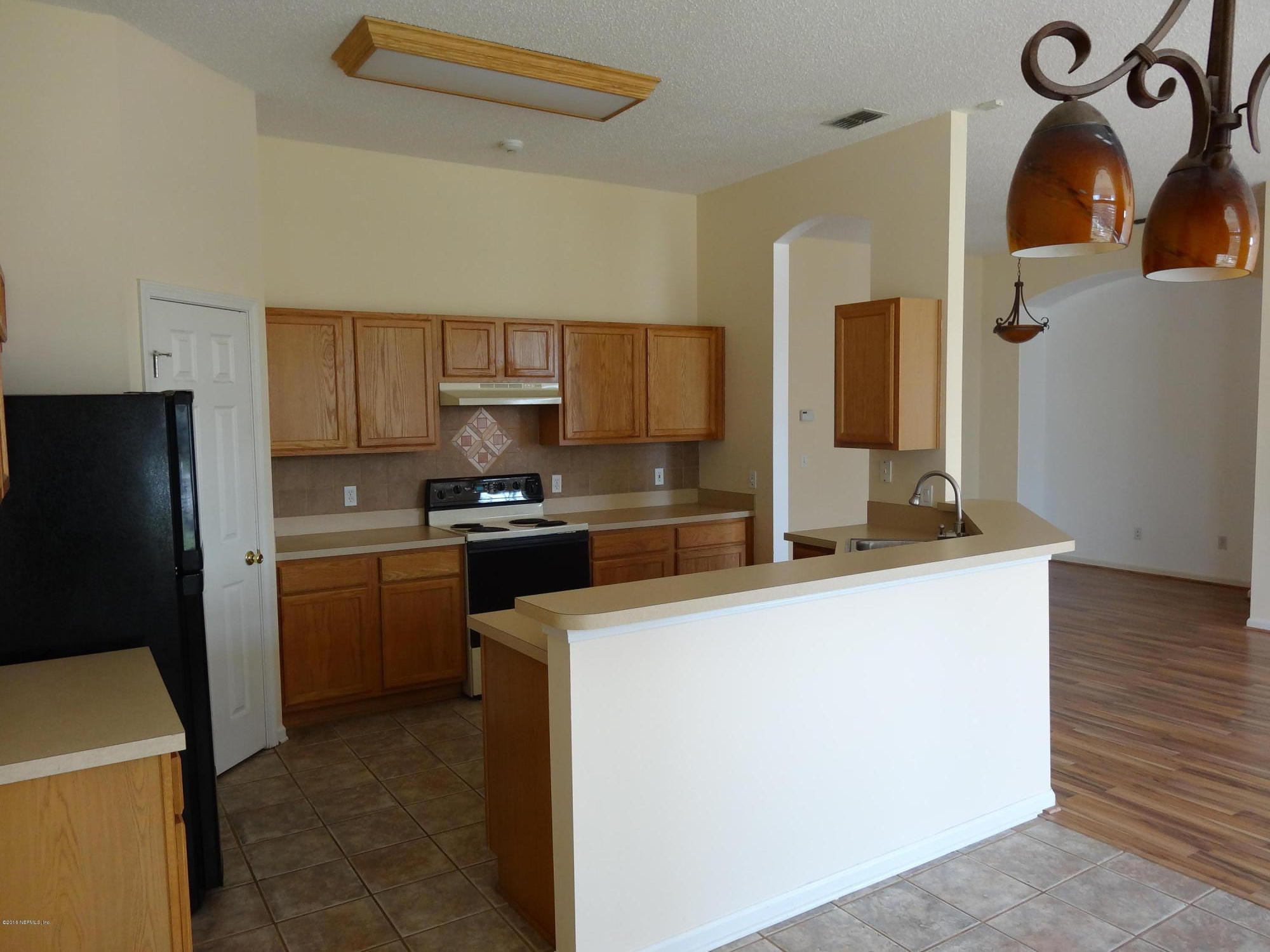 612 Morning Mist Way Orange Park, FL 32073 - Photo 4 of 12 a kitchen with stainless steel appliances a sink a stove a refrigerator and cabinets