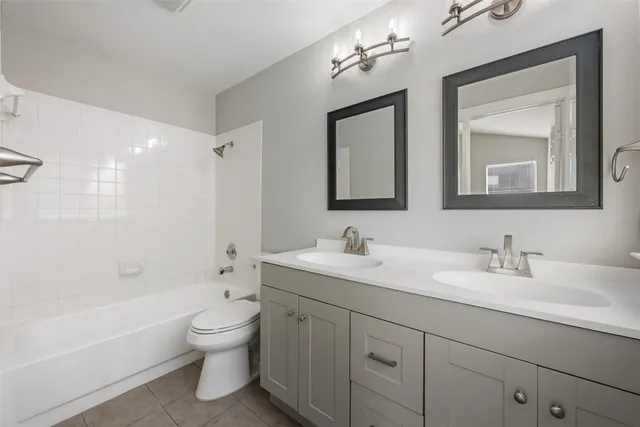 an empty room with wooden floor chandelier fan and windows