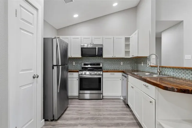a kitchen with stainless steel appliances granite countertop a refrigerator and a stove top oven