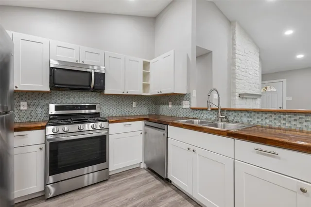 a kitchen with granite countertop a stove a microwave a sink and cabinets