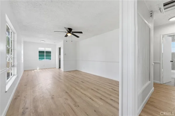 a view of a livingroom with wooden floor and a ceiling fan