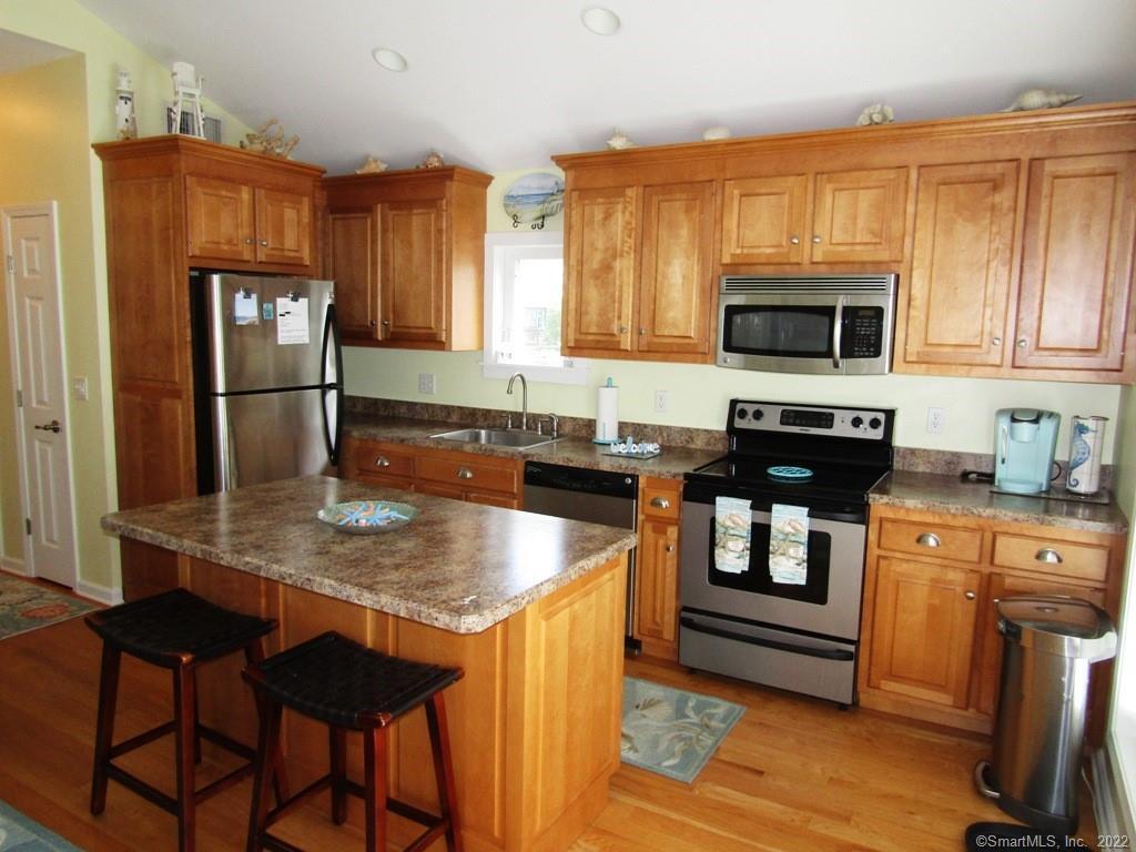 a kitchen with granite countertop a stove a sink and a microwave