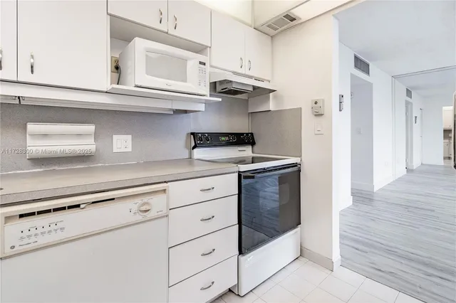 a kitchen with stainless steel appliances granite countertop a refrigerator and a stove