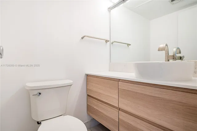 a bathroom with a toilet a sink and vanity