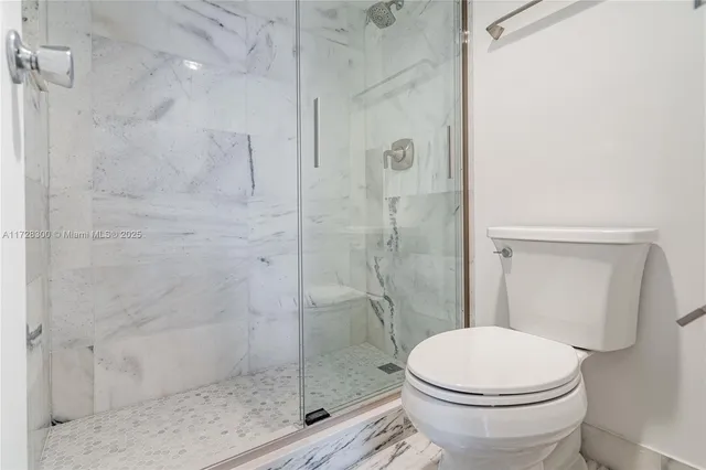 a bathroom with a toilet and a shower