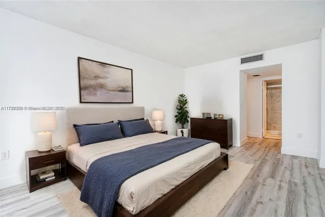 a bedroom with a bed and a painting on the wall