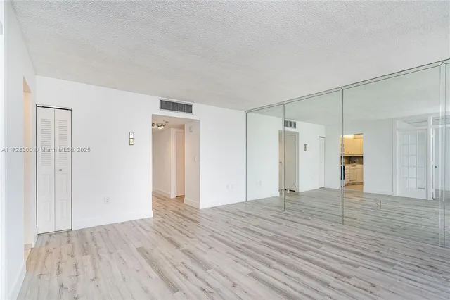 a view of empty room with wooden floor