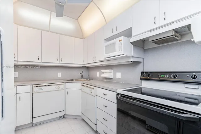 a kitchen with white cabinets and white appliances