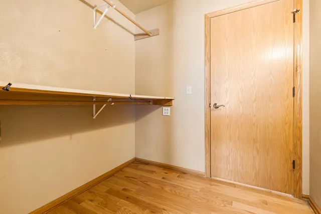 an empty room with a window and a ceiling fan