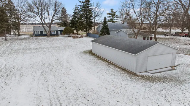 a backyard of a house with wooden fence and large trees