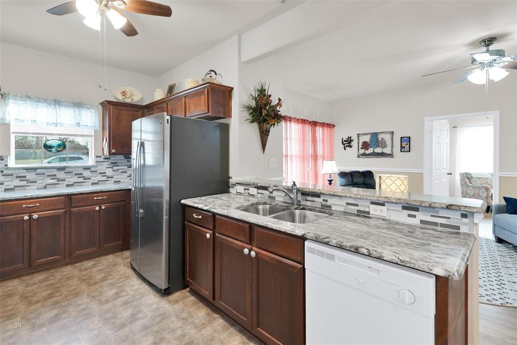 201 East Walker Street Denison, TX 75021 - Photo 8 of 19 a kitchen with stainless steel appliances granite countertop a sink stove and refrigerator