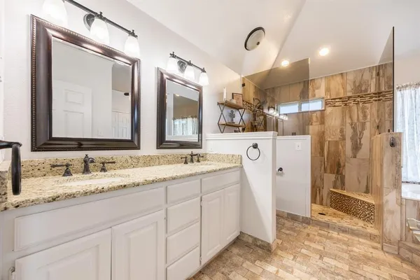 a bathroom with a granite countertop sink a toilet and shower