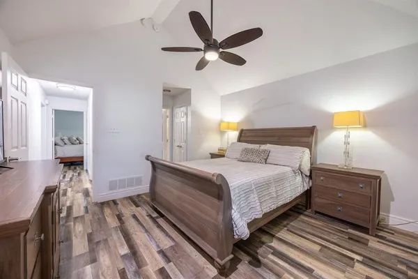 a bathroom with a granite countertop sink a toilet a mirror and shower