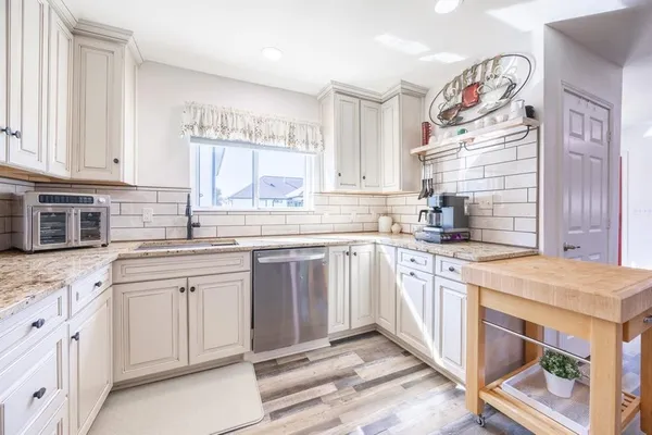 a kitchen with granite countertop white cabinets and stainless steel appliances