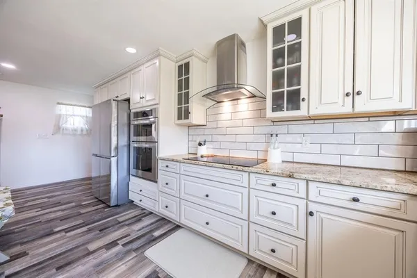 a kitchen with stainless steel appliances a refrigerator and a stove top oven