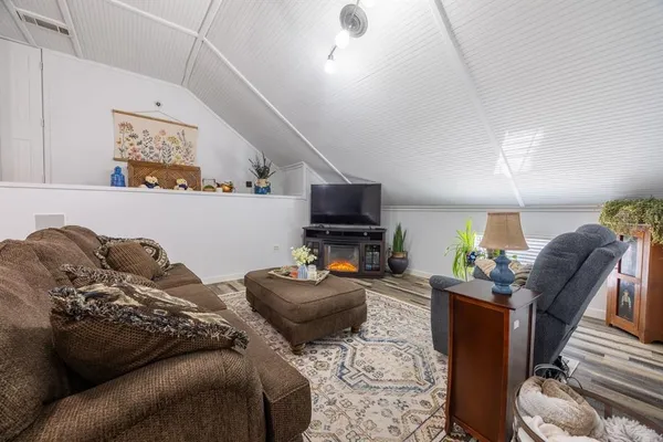 a living room with furniture a flat screen tv and a window