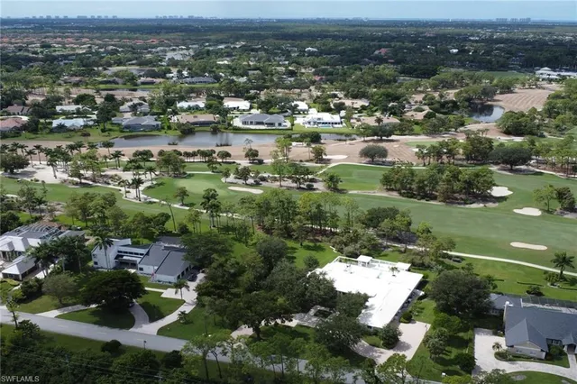 an aerial view of residential houses with outdoor space and trees