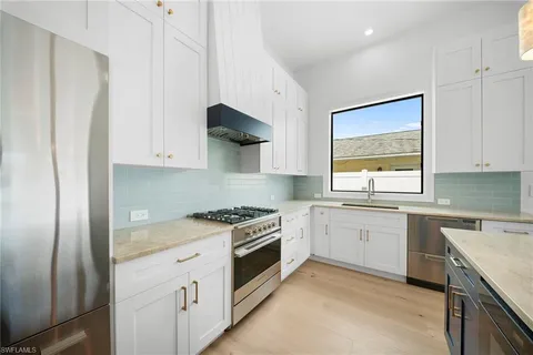 a kitchen with stainless steel appliances granite countertop a sink stove and refrigerator