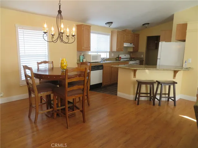 a dining room with furniture a chandelier and kitchen view