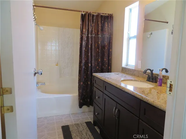 a bathroom with a granite countertop sink a toilet and a mirror