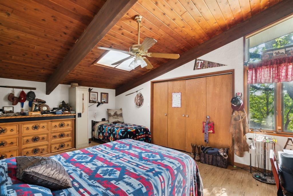 2710 Advance Road Poolville, TX 76487 - Photo 17 of 40 a bedroom with a bed and a chandelier