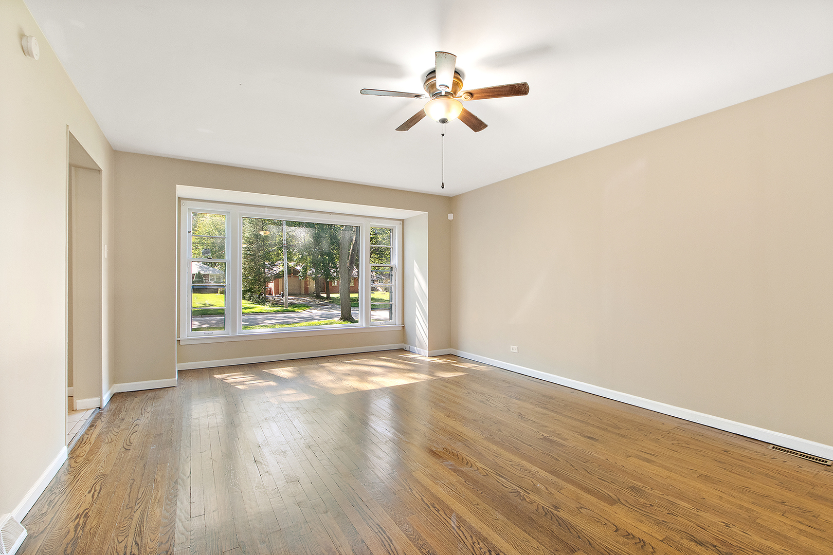 1718 West 187th Street Homewood, IL 60430 - Photo 5 of 28 an empty room with wooden floor fan and windows