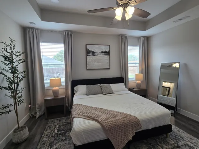 a bedroom with a large bed and a chandelier