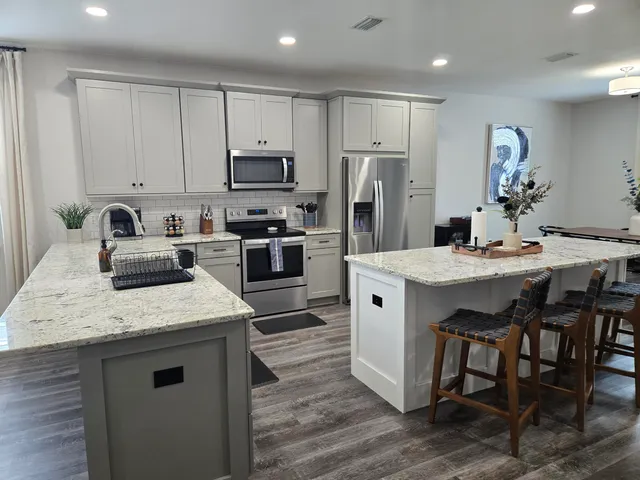 a kitchen with stainless steel appliances granite countertop a white cabinets and a stove top oven