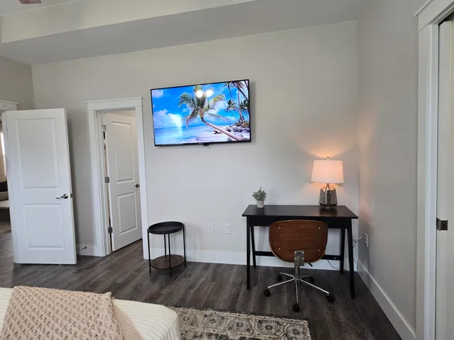a view of a workspace with furniture and wooden floor
