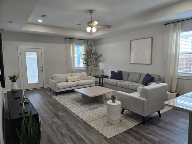 a living room with furniture a rug and a chandelier