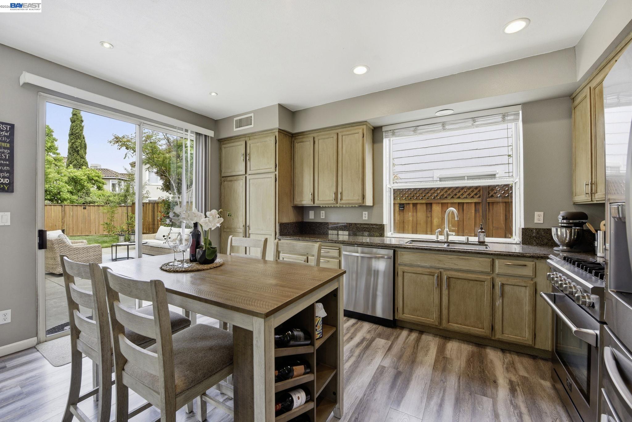 36939 Papaya Street Newark, CA 94560 - Photo 13 of 49 a kitchen with a stove a sink a kitchen island with a dining table and chairs