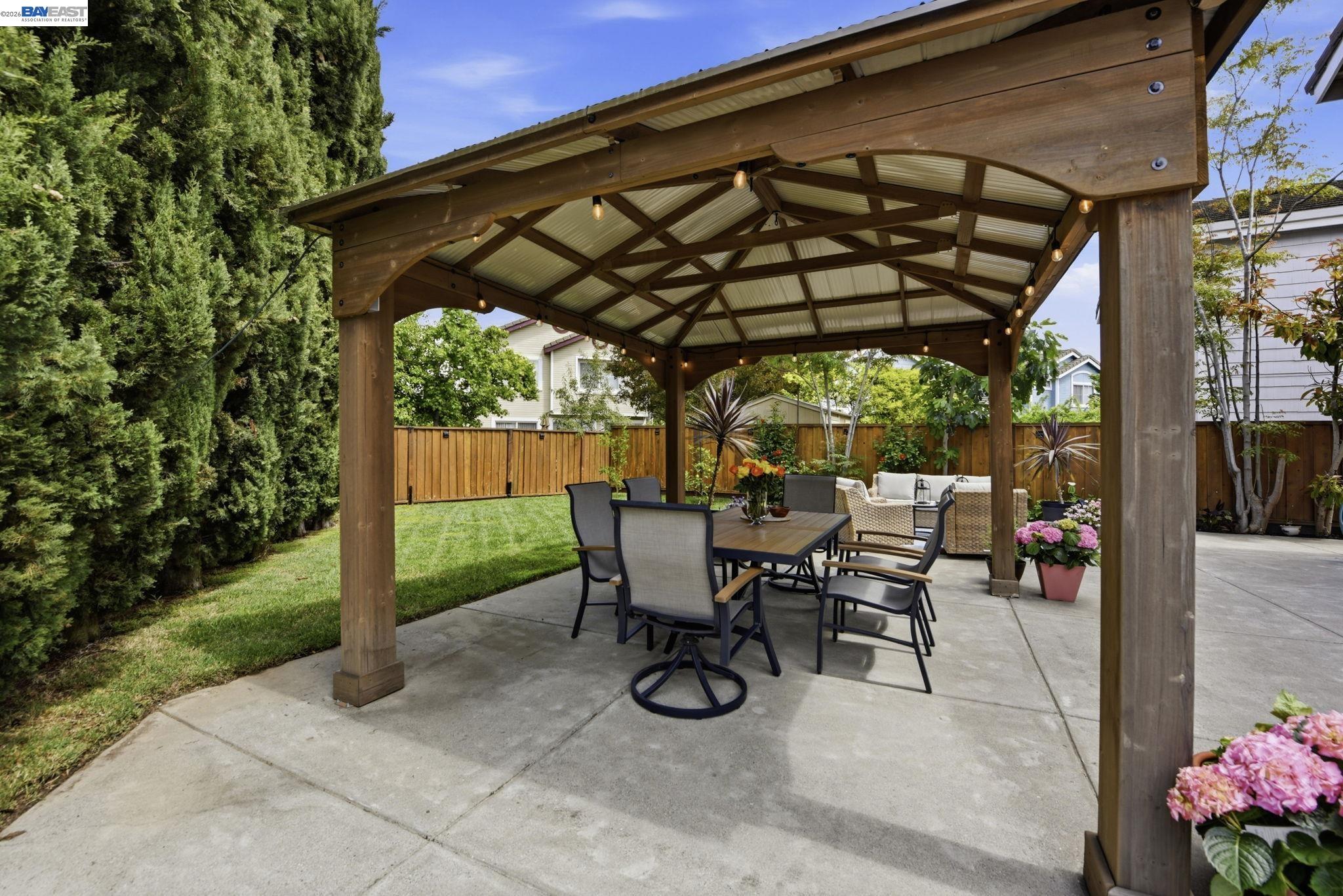 36939 Papaya Street Newark, CA 94560 - Photo 39 of 49 a view of patio with table and chairs under an umbrella with a small yard