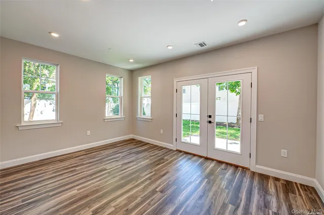 a view of a big room with wooden floor and windows