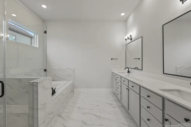 a spacious bathroom with double sink and a bathtub