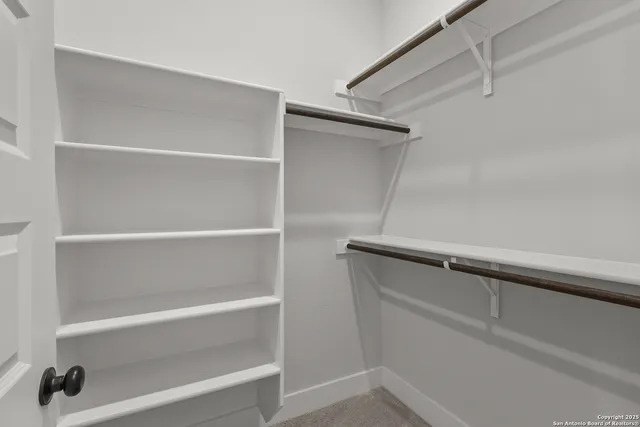 a view of walk in closet with empty racks