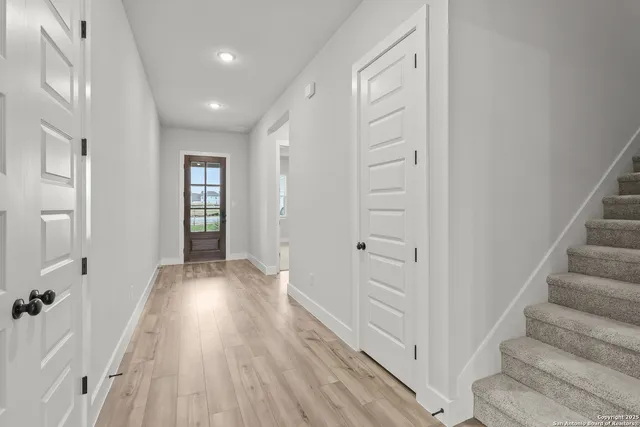 a view of an entryway with wooden floor and staircase