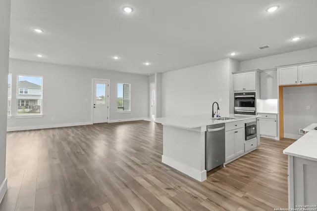a view of kitchen with wooden floor and electronic appliances