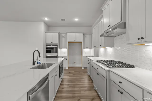 a kitchen with kitchen island stainless steel appliances sink stove and cabinets
