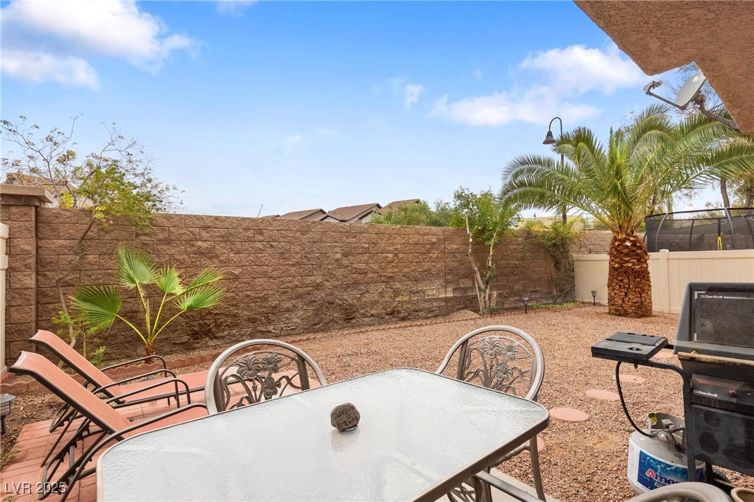 1289 Large Cap Drive, Unit 2 Henderson, NV 89074 - Photo 24 of 32 Fenced backyard with a patio area, outdoor dining area, and a grill