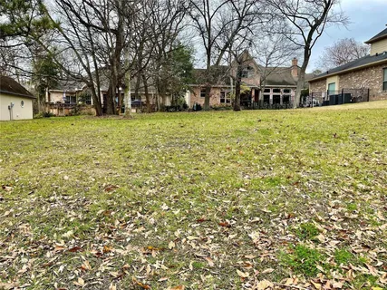 a view of a yard with a house and large trees