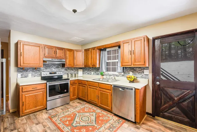 a kitchen with stainless steel appliances granite countertop a refrigerator and a stove top oven