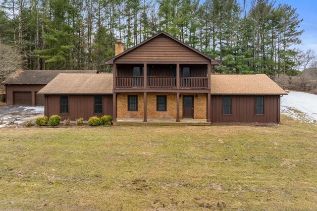 a front view of a house with yard and green space