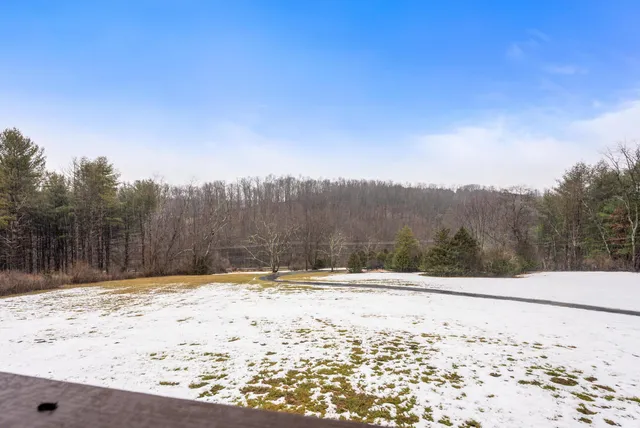 a view of an empty room with wooden floor and closet