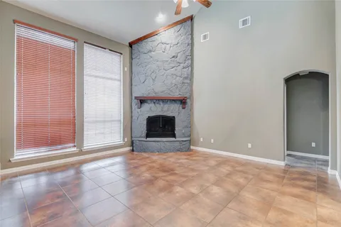 a view of an empty room with a fireplace and a window