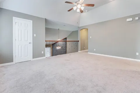 a view of an empty room with a chandelier fan