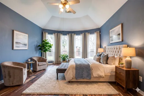 a bedroom with bed a chandelier and a window