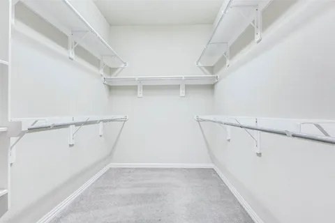 a view of walk in closet with empty racks