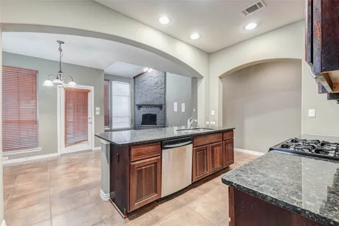 a kitchen with kitchen island granite countertop a sink and a stove